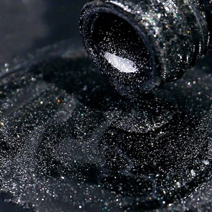 Macro shot of shimmering black cat-eye nail gel with dense sparkling galactic glitter