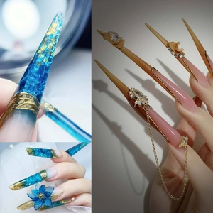Artistic long press-on nails with blue petals, gold foil, and 3D floral chain details