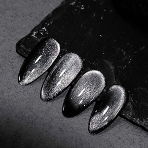 Macro detail of dark cat eye nail polish with silver magnetic shimmer on black stone
