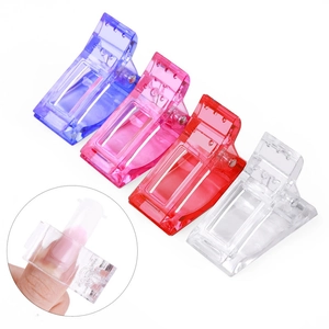 Close-up of translucent nail tip clips for extension and UV gel curing fixator