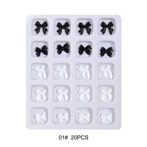 Detailed view of 20 black and white 3D resin butterfly nail art decorations in a tray