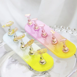 Detail of gradient acrylic nail display stand with magnetic metal holders on fabric
