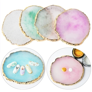 Macro detail of resin nail art palettes with golden edges for mixing polish and display