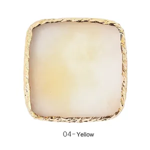 Macro-opname van geel marmeren hars nagelpalet met getextureerde gouden metalen rand