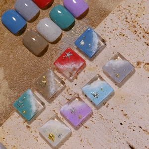 Salt sand texture nail gel polish and sea theme charms on mineral stone display