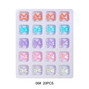 Macro detail of 20pcs 3D aurora butterfly resin nail charms in a plastic storage tray