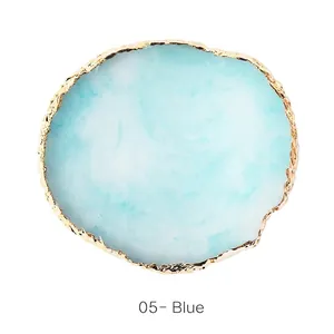 Detail of round resin agate nail art palette in blue with luxury gold foil edge