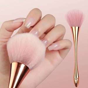 Detail of soft pink fiber bristles and rose gold metallic handle of makeup brush