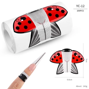 Macro detail of red and black ladybug nail extension forms with ruler scale marks