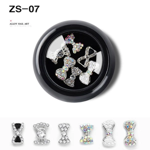 Detailed macro view of mixed alloy nail art charms with rhinestones and bow designs