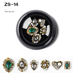 Macro detail of alloy nail art gems with emerald rhinestones and gold settings
