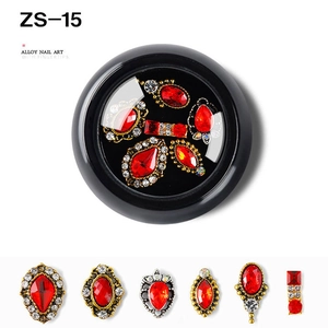 Macro shot of assorted red alloy nail art charms with crystal accents in a round case