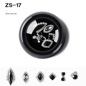 Detail view of alloy nail art rhinestones with black and silver bow designs in a round case