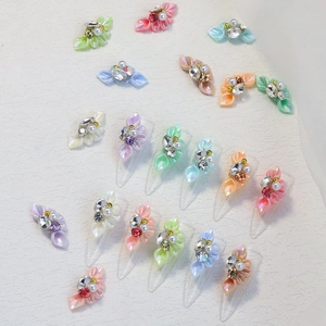 Detailed view of 3D resin floral nail charms with rhinestones and pearls in pastel colors