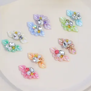 Macro shot of 3D resin floral nail art charms with pearls and colorful pearlescent finish
