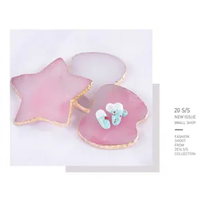 Star-shaped resin nail art palette with gold trim on white silk background