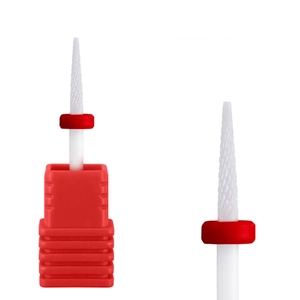Détail macro de l'embout à ongle en céramique blanche avec dents croisées et anneau rouge