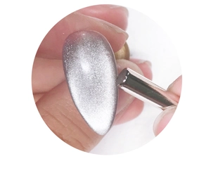Detailed demonstration of using a cylindrical magnet to create silver cat eye nail art effect