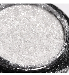 Vista macro di polvere glitterata fine argento per nail art in un contenitore nero
