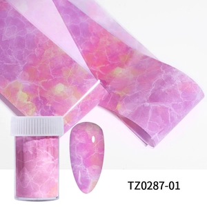 Detail view of pink purple marble nail transfer stickers with decorative storage bottle