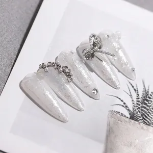 Unghie finte lusso bianco perlato e glitter argento con fiocco 3D e dettagli strass