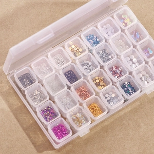 Transparent 28-slot storage box filled with colorful nail art rhinestones and beads