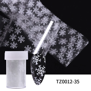 Close-up of white snowflake nail transfer foil with storage jar and black nail sample