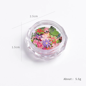 Gekleurde houten bloemvlokken voor nail art in een transparant rond opbergdoosje