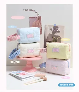 Dettaglio di quattro pochette per cosmetici trapuntate con manici in pizzo e etichette