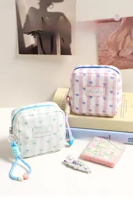 Detail of pink and blue quilted striped mini bags with heart pattern and woven zip puller