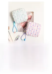 Close-up of quilted cotton makeup bags with stripes, heart charms, and woven rope handles