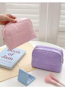 Close-up of pink and purple quilted down cosmetic bags with high-gloss nylon texture
