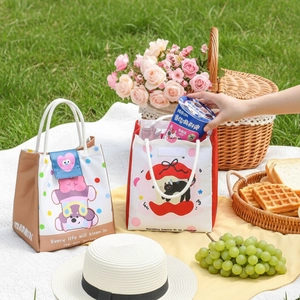 Insulated cartoon animal lunch bags with rope handles on a scenic picnic grass background
