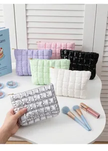 Detailed view of six quilted puffer makeup bags in metallic silver, purple, pink and white