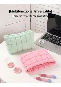 Detail van gewatteerde katoenen make-uptas met gouden rits in een lifestyle setting