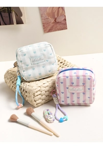 Detail of canvas makeup bags with heart patterns, stripe prints and woven zipper pulls