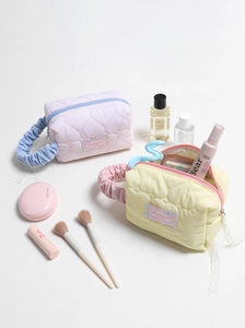 Dettaglio di trousse trapuntate a cuore con accenti in pizzo e manici arricciati