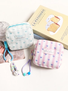 Striped heart makeup bags with colorful lanyards on decorative pastel background