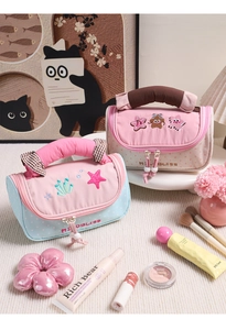 Dettaglio della trousse in tela macaron con ricamo a forma di orsetto e colori a contrasto