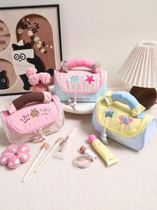 Dettaglio di pochette ricamate macaron con manici imbottiti e nappe decorative