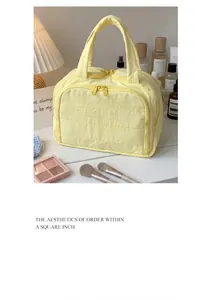 Quilted cotton makeup bag in pale yellow color with double zipper and soft handle
