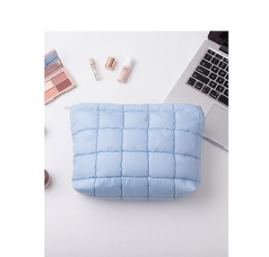 Neceser acolchado azul con cremallera junto a cosméticos y un ordenador portátil