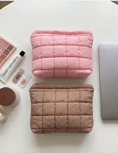 Primer plano de neceseres acolchados en rosa y marrón con cremallera para viajes