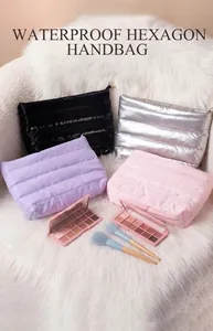 Quilted cosmetic bags in various colors displayed on a white faux fur background