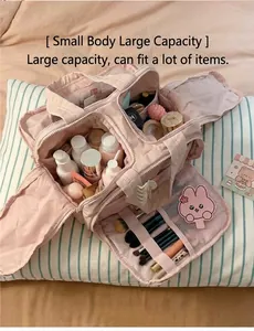 Detailed interior of a pink quilted makeup bag showing brush slots and mesh pockets