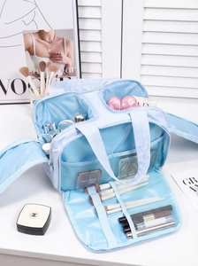 Detail view of large sky blue makeup bag featuring multiple compartments and brush slots