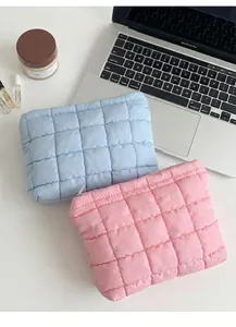 Detalle de neceseres acolchados en rosa y azul con cremallera superior y textura suave