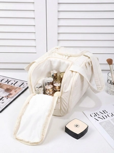 Detail showing the wide interior of a cream quilted toiletry bag with skin care products