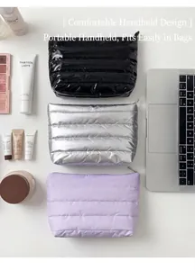Flat lay of three quilted makeup bags in black, silver, and lilac with cosmetics