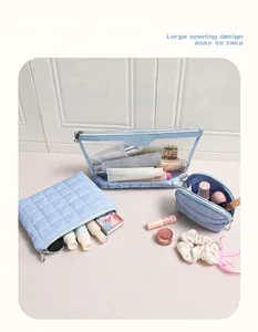 Macro view of light blue quilted cosmetic bag set featuring three versatile travel pouches